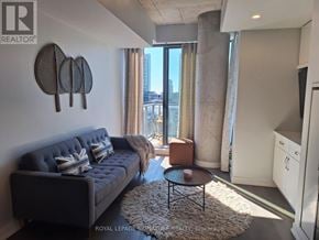 Toronto (Waterfront Communities) condo for rent - A living room with a grey sofa and a coffee table.