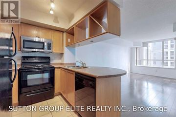 Mississauga (City Centre) condo for rent - A kitchen with wooden cabinets and a black stove top oven.