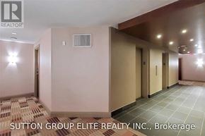 Mississauga (City Centre) condo for rent - A hallway with a tiled floor and walls painted in a light color, with a brokerage sign for Sutton Group Elite Realty Inc.