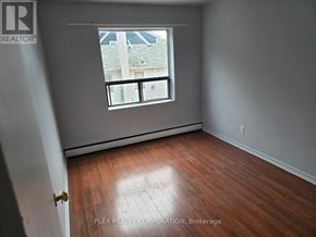 Toronto (Mimico) multi-family for rent - A room with a window and wooden flooring.