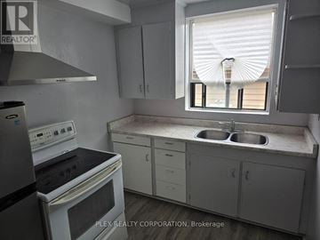 Toronto (Mimico) multi-family for rent - A kitchen with a stove, sink, and cabinets.