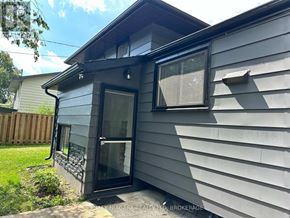 Welland (N. Welland) apartment for rent - A house with a grey siding and a black door is shown.