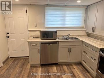Welland (N. Welland) apartment for rent - A kitchen with white cabinets and a wooden floor.
