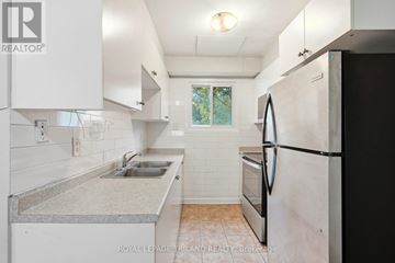 London East (East H) townhouse for rent - A kitchen with white cabinets and a black refrigerator.