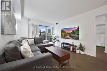Toronto (Waterfront Communities) condo for rent - A living room with a grey couch and a wooden coffee table.