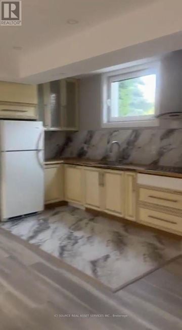 Vaughan (Kleinburg) apartment for rent - A kitchen with a white refrigerator and marble flooring.