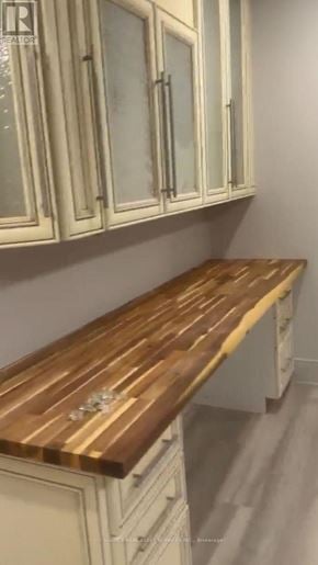 Vaughan (Kleinburg) apartment for rent - A kitchen with white cabinets and a wooden countertop.