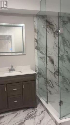 Vaughan (Kleinburg) apartment for rent - A bathroom with a marble floor and a glass shower stall.