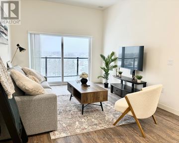 Belleville (Belleville Ward) multi-family for rent - A living room with a grey couch, a wooden coffee table, a white chair, and a flat screen TV.