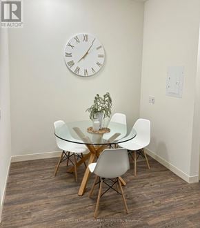 Belleville (Belleville Ward) multi-family for rent - A glass dining table with four chairs and a clock on the wall.