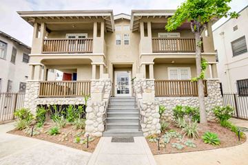 Los Angeles apartment for rent - A beige two-story apartment building with a front yard and stairs leading to the entrance.