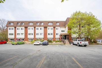 Dartmouth apartment for rent - A parking lot in front of a multi-story apartment building with cars parked in the lot.