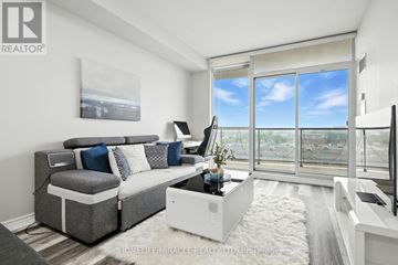 Toronto (Wexford-Maryvale) condo for rent - A living room with a grey couch and a large window.