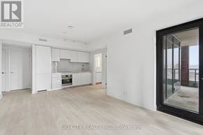 Toronto (Thorncliffe Park) condo for rent - A spacious kitchen with white cabinets and a large window.