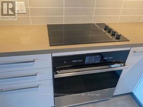 Markham (Commerce Valley) condo for rent - A modern kitchen with a stove top oven and a tile backsplash.