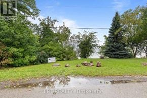 Georgina (Historic Lakeshore Communities) apartment for rent - A sign in front of a green area with trees.