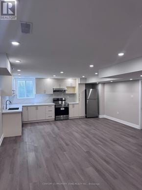 Caledon apartment for rent - A well-lit, spacious kitchen with grey flooring and white cabinetry.