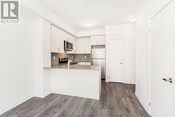 Mississauga (Erin Mills) townhouse for rent - A kitchen with white cabinets and a wooden floor.