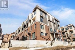 Mississauga (Erin Mills) townhouse for rent - A modern apartment building with a clear blue sky in the background.
