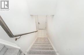 Mississauga (Erin Mills) townhouse for rent - A stairway with a wooden handrail and a white wall.