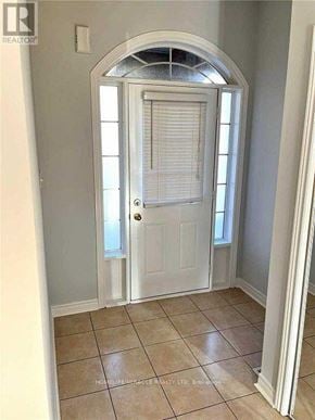 Mississauga (Hurontario) apartment for rent - A white door with a window above it is in a room with a tiled floor.