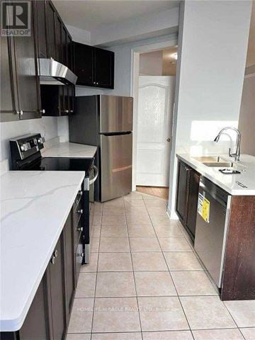 Mississauga (Hurontario) apartment for rent - A kitchen with black cabinets and a white counter top.
