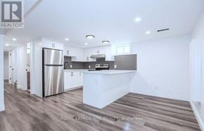 St. Catharines (Carlton/Bunting) apartment for rent - A modern kitchen with white cabinets and a stainless steel refrigerator.