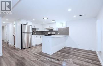 St. Catharines (Carlton/Bunting) apartment for rent - A modern kitchen with white cabinets and a stainless steel refrigerator.