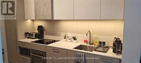 Toronto (Niagara) condo for rent - A kitchen with a sink, stove, and refrigerator.