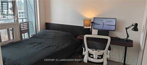 Toronto (Niagara) condo for rent - A bedroom with a bed, desk, and chair.