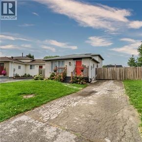 London apartment for rent - A house with a red door is surrounded by a wooden fence and has a driveway leading to the front door.