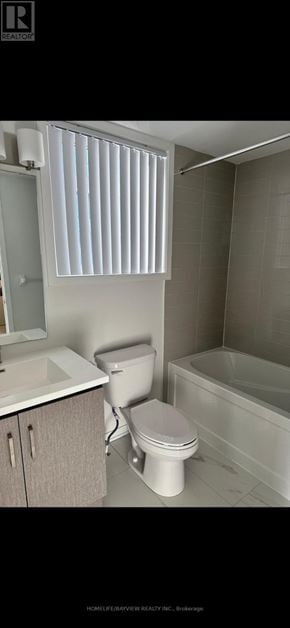 Vaughan (Vaughan Corporate Centre) townhouse for rent - A white toilet is in a bathroom with a white tub.