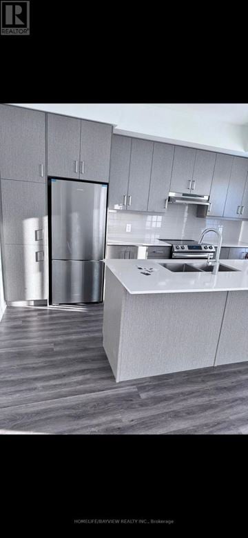 Vaughan (Vaughan Corporate Centre) townhouse for rent - A modern kitchen with a refrigerator, sink, and cabinets.