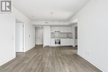 Toronto (Thorncliffe Park) condo for rent - A spacious kitchen with white cabinets and a wooden floor.