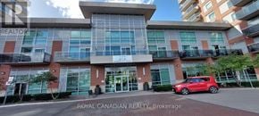 Brampton (Queen Street Corridor) condo for rent - A red car is parked in front of a building with the sign "Royal Canadian Realty Brokerage".