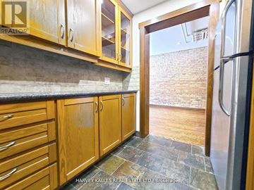 Toronto (Church-Yonge Corridor) multi-family for rent - A kitchen with wooden cabinets and a stone floor.