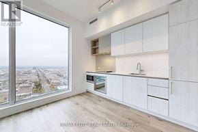 Vaughan (Vaughan Corporate Centre) condo for rent - A kitchen with white cabinets and a view of the city.