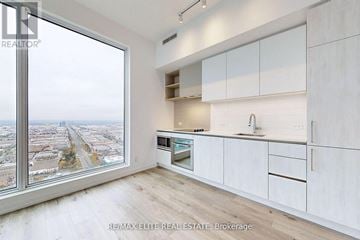 Vaughan (Vaughan Corporate Centre) condo for rent - A kitchen with white cabinets and a view of the city.