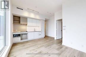 Vaughan (Vaughan Corporate Centre) condo for rent - A modern kitchen with white cabinets and wooden floors.