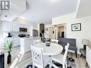 Richmond Hill (Mill Pond) townhouse for rent - A modern kitchen with white cabinets and a dining table set for two.