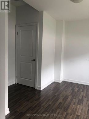Vaughan (Vaughan Grove) townhouse for rent - A room with a wooden floor and a white door.