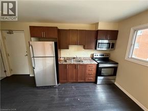 Kitchener apartment for rent - A kitchen with a refrigerator, microwave, oven, and sink.