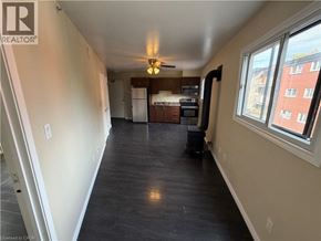Kitchener apartment for rent - A spacious living room with a kitchen in the background.