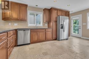 Woodstock (Woodstock - South) duplex for rent - A kitchen with wooden cabinets and a refrigerator.