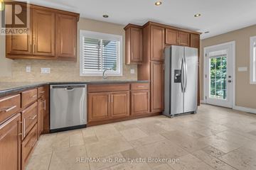 Woodstock (Woodstock - South) duplex for rent - A kitchen with wooden cabinets and a refrigerator.