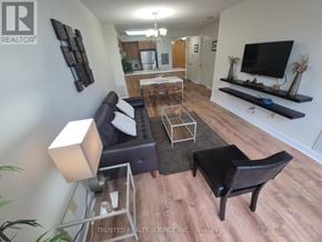 Toronto (Yonge-Eglinton) condo for rent - A living room with a black leather couch and a wooden coffee table.