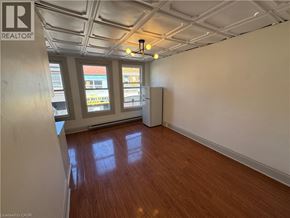 Kitchener apartment for rent - A room with wooden floors and white walls.