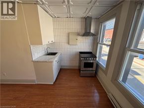 Kitchener apartment for rent - A kitchen with a stove, oven, and sink.