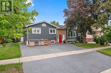 Orangeville apartment for rent - A house with a grey exterior and a red door is for sale.