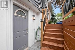 Orangeville apartment for rent - A grey door with a wooden staircase leading to it.